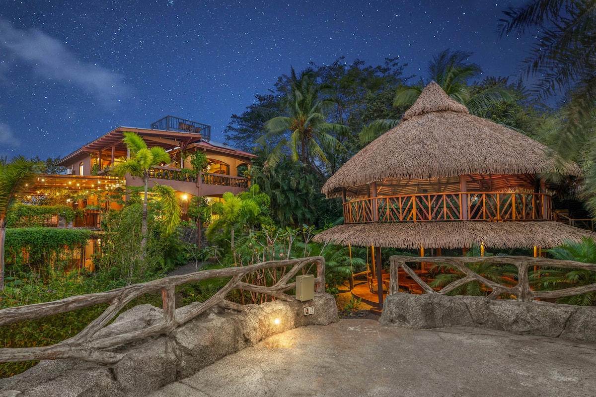 The open-air thatched yoga shala glowing warmly beneath a starlit sky