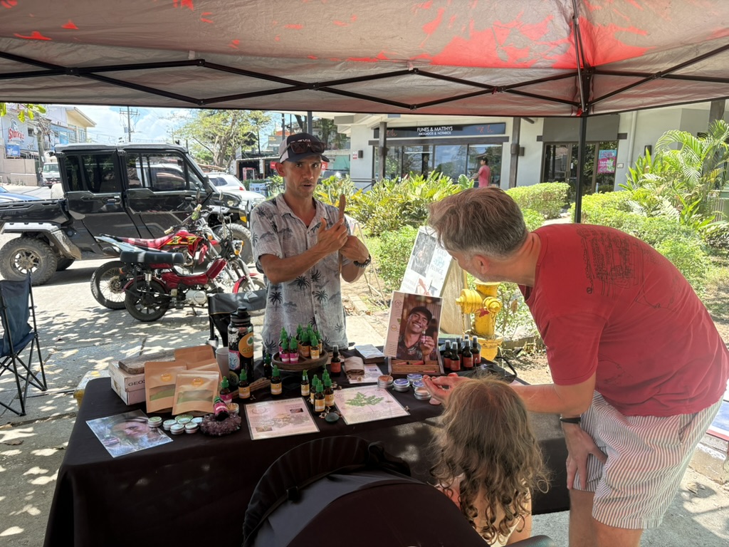 A friendly maker chatting with visitors at his stall at the local town market